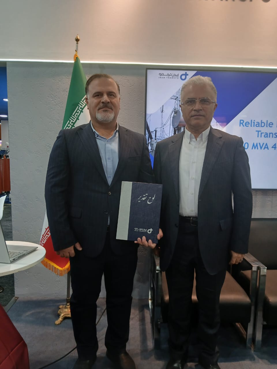 مرتضی عبدالهی لوح تقدیر خود را به عادل سلیمانی، مدیرعامل برق منطقه‌ای گیلان، اهدا می‌کند