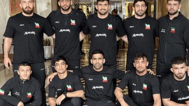 تیم ملی کشتی آزاد ایران بر سکوی قهرمانی آسیا در بیشکک همراه با پرچم ایران و مدال‌های طلا، نقره و برنز
