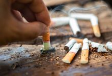 بسته سیگار نخی و چند نخ سیگار بازشده روی پیشخوان مغازه